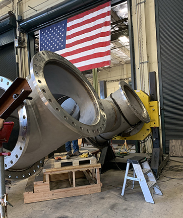 A close up image of a complex steel pipe assembly that is being custom fabricated at PMI's pipe fabrication shop in Sacramento.